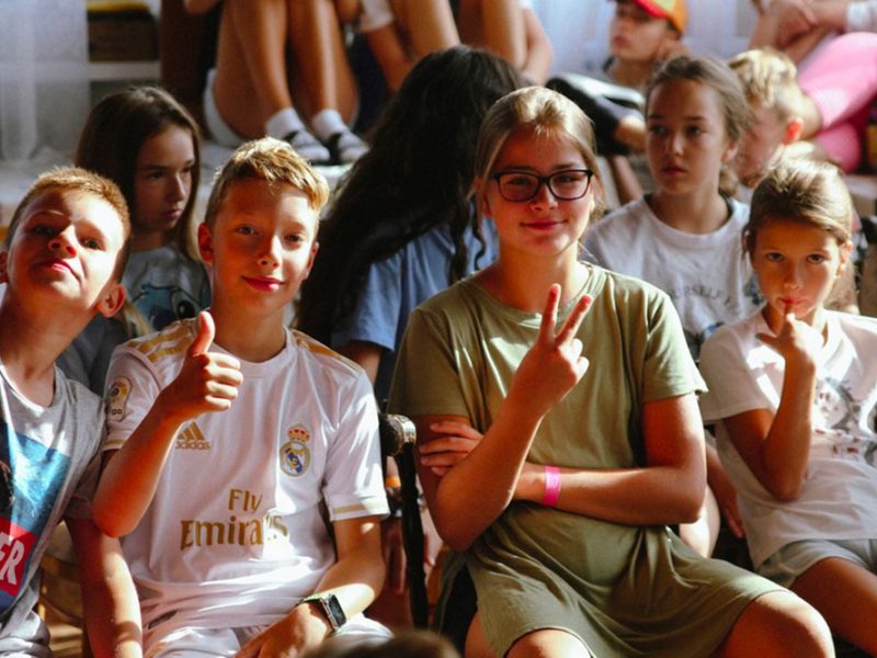 Un-gruppo-di-ragazzini-e-ragazzine-sorridenti-a-un-evento-pubblico-1pe1gr